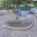 Modern Wave Shaped Outdoor Chairs With Trees On Pebble Paved Ground