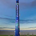 Tall Illuminated Landscape Column Against Evening Sky With Colorful Lights And Ornaments