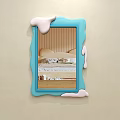 Blue Frame Mirror With Melted Cream Effect Reflecting Bed Pillows And Quilt On Beige Wall
