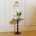 Black Round Side Table With Decorative Pedestal Green Plant And White Mug On Wooden Floor
