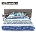 Tufted Headboard Bed With Blue And White Patterned Bedding And Small Round Side Table