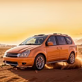 Orange SUV Off Road Driving In Desert At Sunset With Mountain Background