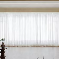 Sheer White Curtains In Bright Living Room With Wooden Floor And Plant