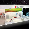 SUNTECH Exhibition Booth Red White Design With Top Logo Large Screen And Green Field