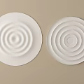 Two White Round Ceiling Light Panels With Concentric Circle Patterns On Beige Wall