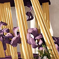 Elegant Floral Art Installation With Purple Frame Yellow Curtains And Purple Pink Floral Arrangements