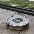 Robot Vacuum Cleaner Operating On Wooden Floor With Outdoor Grass View