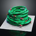 Neatly Coiled Green Cable With Red Ends Placed On Gray Mat