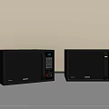 Two Black Samsung Microwaves Side by Side on Gray Countertop with Beige Kitchen Wall