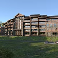 Hotel Building With Wooden And Stone Exterior In Green Natural Surroundings With Lawn And Trees