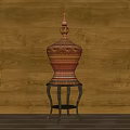 Red And Orange Carved Sculpture On Black Metal Stand With Wooden Wall Background