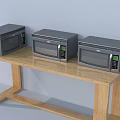Three Modern Microwaves With Digital Display As Kitchen Appliances On Wooden Table
