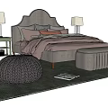 Modern Double Bed With Arched Headboard Multiple Pillows Nightstands Table Lamps Knitted Ottoman And Cozy Rug