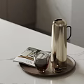 Silver Vacuum Flask As Daily Electrical Appliance On Tray With Glass Cup And Magazine