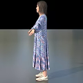 Woman In Blue Purple Floral Long Sleeve Dress Standing With Arms Outstretched On Gray Background