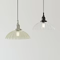 Modern Pendant Lights With White And Black Scalloped Translucent Shades Illuminated On Light Colored Wall