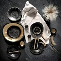 Black Gold Dinnerware Set With Plates Bowls Cups Glassware Feather Decor On Gray Textured Background