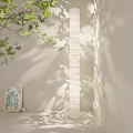 White Floor Lamp With Hollow Out Pattern Casting Shadow Near Green Plant And Picture Frame