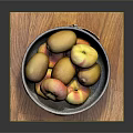 Fresh Yellow And Red Mixed Fruits In Black Bowl On Wooden Cutting Board