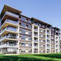 Modern Multi Story Apartment Building Exterior With Green Lawn And Clear Blue Sky