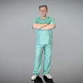 Man in Light Green Scrubs Standing with Arms Crossed Against Gray Background