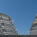 Modern Office Building With Glass Facade Greenery Road Cars Under Blue Sky And White Clouds