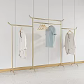Golden Metal Clothes Racks With White Shirt Light Blue T Shirt And Light Colored Cardigan