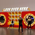Red Illuminated Art Installation With Look Over Here Text Circular Mirrors And People Interacting