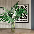 Transparent Glass Vase With White Orchids Large Green Leaves And Abstract Art On Textured Wall