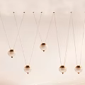 Multiple Unique Shaped Pendant Lights With Spherical Lampshades Golden Bases Suspended On White Background