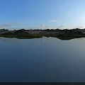 Serene Natural Landscape With Calm Deep Blue Lake Lush Green Islets And Bright Clear Sky