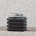 Minimalist Side Table Featuring Stack of Black Books and Open Book on Wooden Top