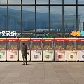 Colorful Outdoor Amusement Equipment With Multiple Claw Machines And Person Standing Near Building