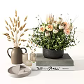 Ceramic Vase With Dried Grass And Black Pot Flower Arrangement On Stacked Books