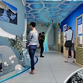 Cultural Center Interior With Visitors Exploring Exhibition Murals Digital Screens And Decorative Flags