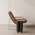 Modern Brown Leather Leisure Chair With Metal Frame And Side Table Against Light Wall