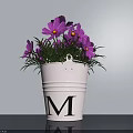White Bucket Flower Pot With Black Letter M And Purple Flowers On Light Gray Wall