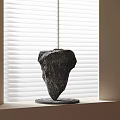 Modern Artistic Black Stone Sculpture Placed On Windowsill With White Blinds