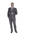 A Man In Professional Gray Suit Standing With Hands In Pockets On Gray Background