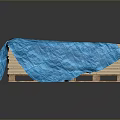 Stacked Wooden Stone Planks Covered With Blue Cloth On Dark Surface