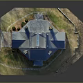 Red Brick Two Story Building With Blue Roof Multiple Chimneys And Grass Courtyard