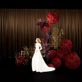 Elegant Floral Installation With Red Spherical Blooms Golden Frames And Woman In White Gown