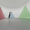 Colorful Geometric Art Installation With Blue Green Red Triangles And Human Figure In White Space