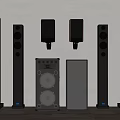 Collection of Various Floor Standing and Wall Mounted Audio Speakers Displayed Against Wall