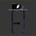 Worn Wooden Table With Blue Rusty Legs Black Box And White Round Object