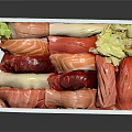 Fresh Sashimi in Wooden Box with Various Fish Slices Green Garnish and Yellow Pickled Ginger