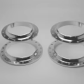 Four Polished Stainless Steel Industrial Flanges with Bolt Holes and Smooth Surface
