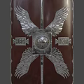 Red Shield With Silver Wing Ornaments And Metallic Center Sphere Design Details