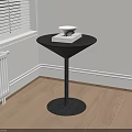 Black Side Table in Corner with White Bowl and Book on Light Wooden Floor