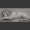 Stone Lion Sculpture Reclining With Curly Mane On Dark Background With Reflection